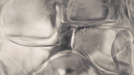 closeup ice cubes water spinning slow motion. refreshing cool beverage concept