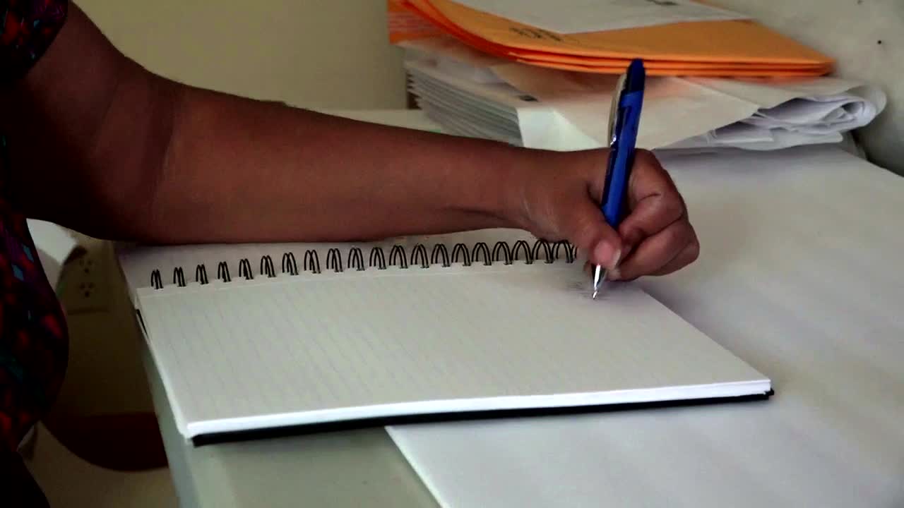 Black woman taking notes in a notebook
