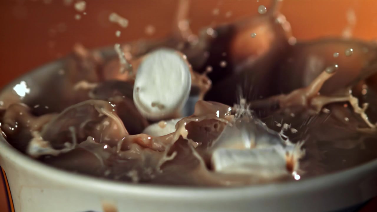 Marshmallow in movimento rallentato che si tuffano nella cioccolata calda