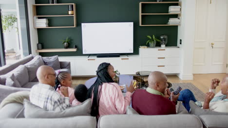 Padres-Afroamericanos,-Hijo,-Hija-Y-Abuelos-Viendo-Televisión-Con-Espacio-Para-Copiar,-Cámara-Lenta