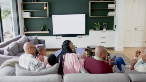 african american parents, son, daughter and grandparents watching tv with copy space, slow motion