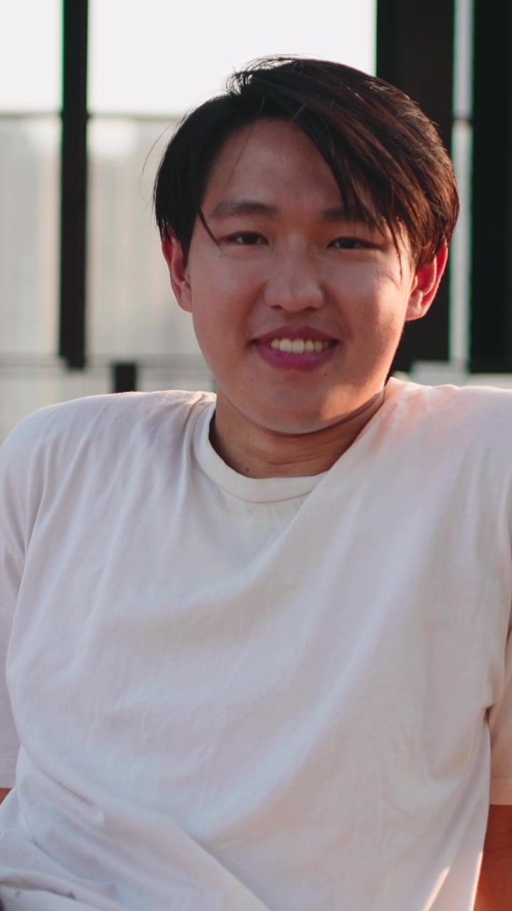 夕阳下户外笑容灿烂的年轻亚洲男子