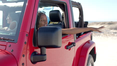 young african american woman enjoys a ride in a red jeep on a road trip