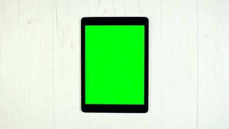 un dedo se desliza en una pantalla verde de la tableta. zoom en el gesto