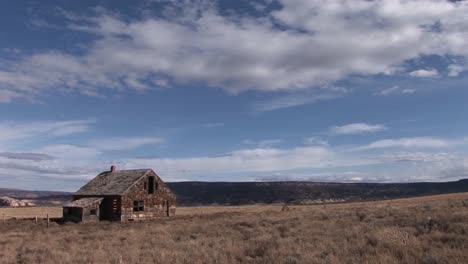 long shot of an old abandoned homestead on a lonely prairie