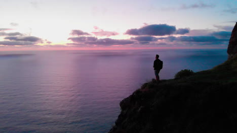 Man-stands-on-hill-watching-sunset-at-Ponta-da-Ladeira-in-Madeira