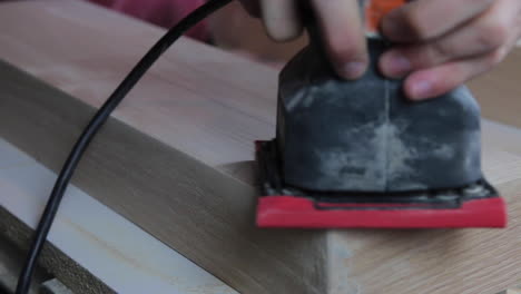 finish sanding the wood filler on wooden floating shelves in preparation to be stained and hung in a remodeled bathroom