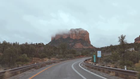 vista de día de conducción lluviosa en sedona con courthouse butte y bell rock