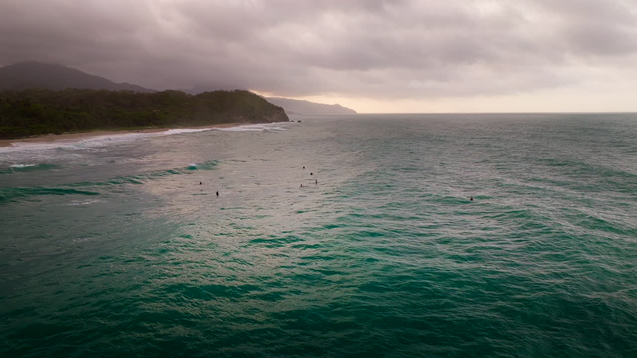 Surfaři čekají na vlnu v Tayrona Los Naranjos během zlaté hodinky, dron