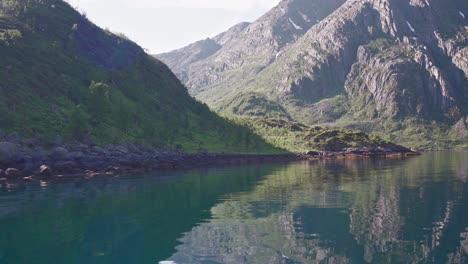 reflections through clear river water with rocky steep slope mountains in norway