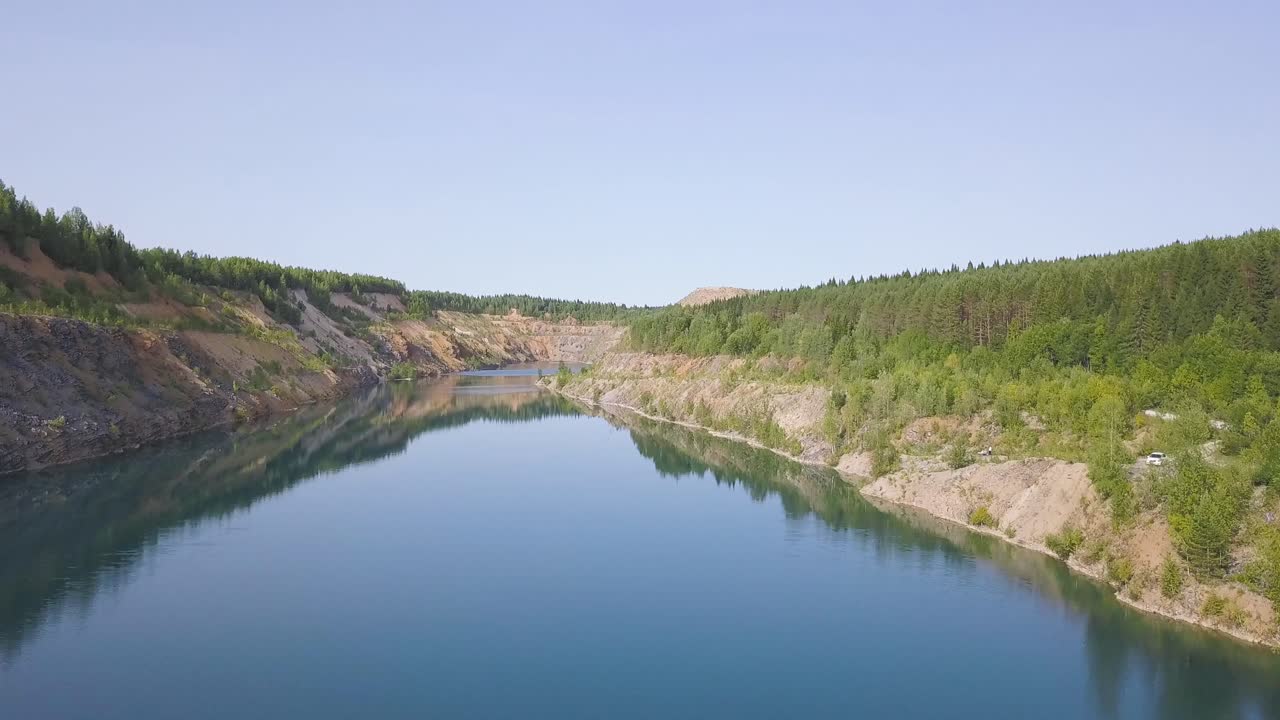 vista aérea de un lago de cantera y el bosque circundante