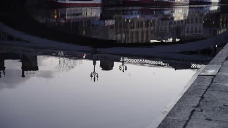 static shot of calm river with bridge reflection and early morning traffic