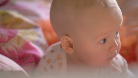 un primer plano de una niña linda en la ropa de cama de colores