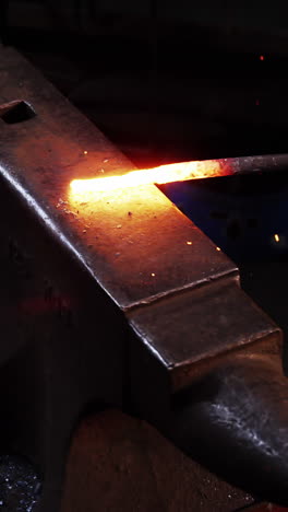 mid-section of blacksmith working on a iron rod