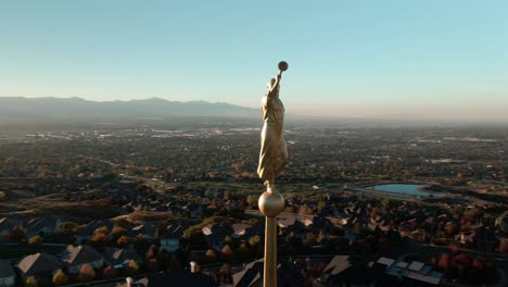 hermosa puesta de sol y primer plano aéreo del ángel moroni en la cima del templo mormón lds draper utah