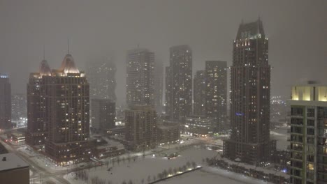 mississauga, ontario, canada, snowstorm, aerial ascend with lights shimmering across buildings