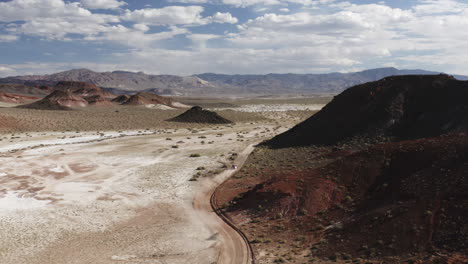 Aerial-drone-flies-above-Red-Rock-Hills-as-a-4x4-truck-explores-the-landscape