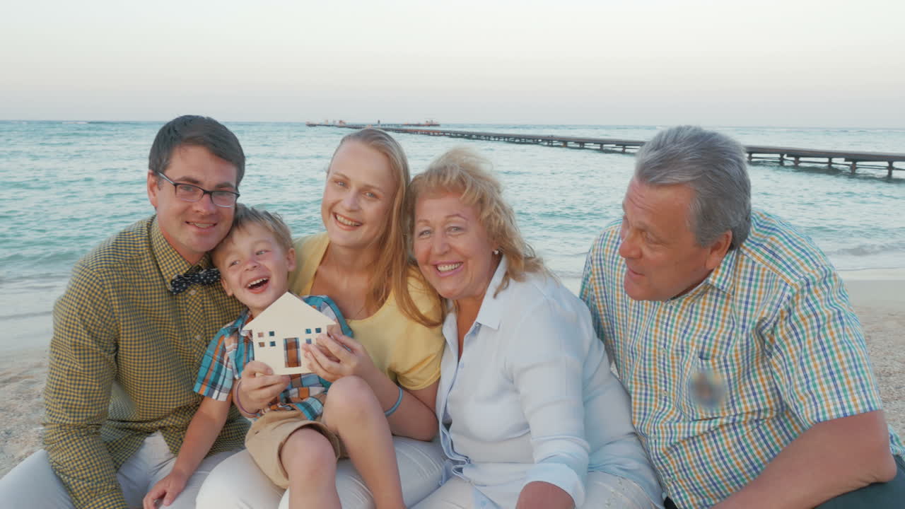 행복한 가족과 작은 목조 집을 가진 부동산 개념