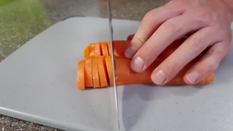 Close-up-of-caucasian-chef-chopping-carrot-on-chopping-board