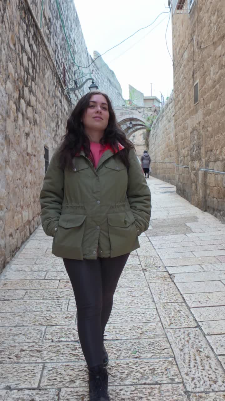 Giovane donna che cammina nella città vecchia di Gerusalemme