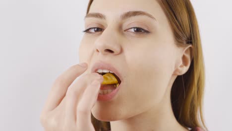 Close-up of woman eating chips.