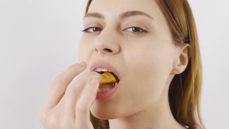 un primer plano de una mujer comiendo papas fritas.