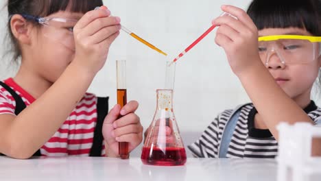 los niños están aprendiendo y haciendo experimentos científicos en el aula. dos hermanas pequeñas jugando a experimentos científicos para la escuela en casa. experimentos científicos fáciles y divertidos para los niños en casa.