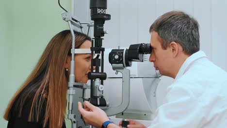 ojos medidos con refractómetro en un óptico u oftalmólogo. oftalmólogo midiendo la presión intraocular de una mujer joven en una clínica