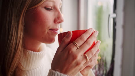 Schöne-Junge-Blonde-Frau-Genießt-Eine-Tasse-Kaffee-Am-Fenster