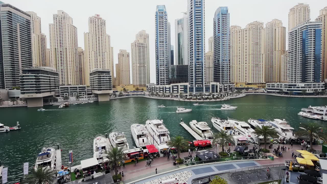 Dubai,United Arab Emirates - October 1, 2021: View of the city's urban density, showing glass skyscrapers, bridges, and the metro line crossing Dubai Marina