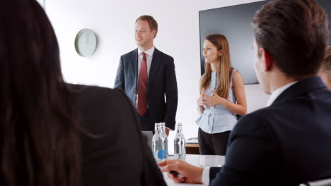 Junger-Geschäftsmann-Und-Geschäftsfrau,-Die-Sich-Am-Tag-Der-Rekrutierungsbewertung-Für-Absolventen-Mit-Gruppentreffen-Am-Tisch-Befassen