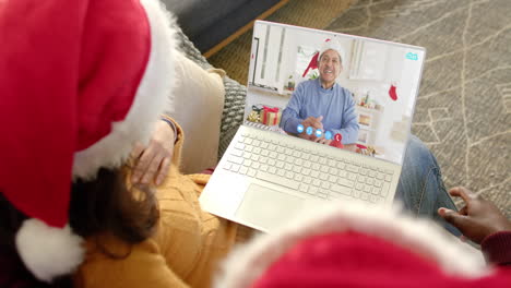 happy diverse couple and senior father having christmas laptop video call, slow motion