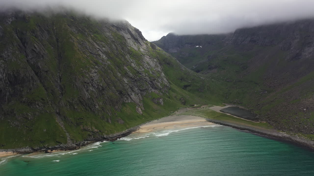 Rotating aerial shot of the isolated Kvalvika Beach in the Lofoten Islands Norway, cinematic drone shot