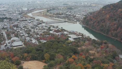 inclinación aérea que revela el puente togetsu-kyo y arashiyama en kioto, japón