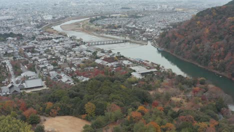 aerial tilt revealing togetsu-kyo bridge and arashiyama in kyoto, japan