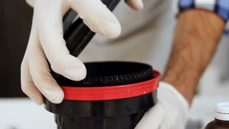 fotógrafo masculino abriendo la cubierta del lente en el estudio fotográfico 4k