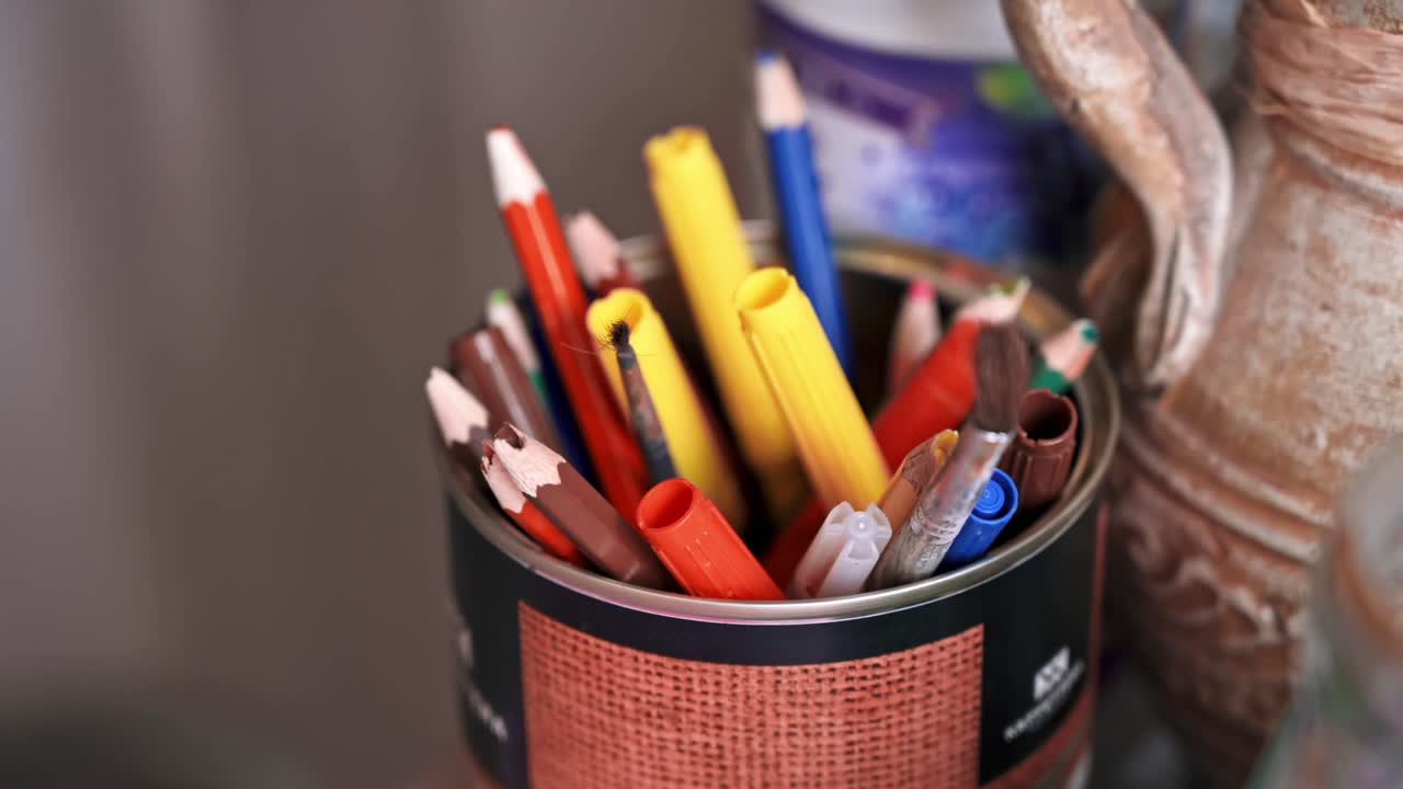 A cup with multiple colored pencils and markers