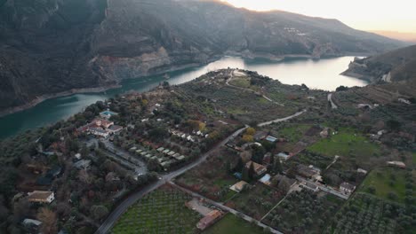 Aerial-view-above-Guejar-agricultural-farming-village-at-the-base-of-the-Sierra-Nevada-mountain-winding-river
