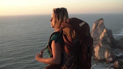 Peaceful-middle-aged-woman-wearing-camping-backpack