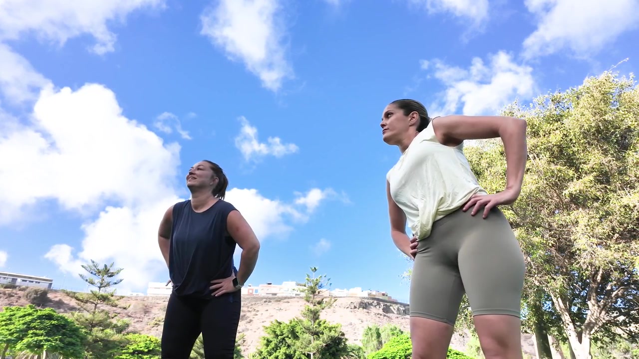 Due giovani donne che fanno stretching insieme nel parco