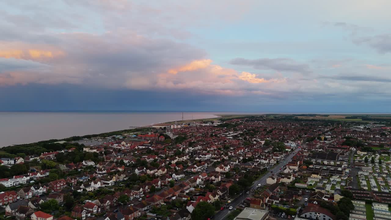 Coastal panorama of the town of Skegness with looming storm clouds over the North Sea. Seaside scene with rooftops at sunset