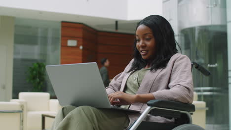 african american businesswoman in wheelchair using laptop