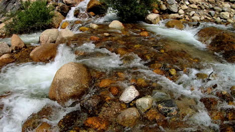 video of fresh water running downstream, through large and small rocks