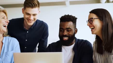diverse team brainstorming around laptop