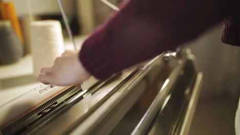 Female-hands-working-on-weaving-machine-in-sewing-workshop