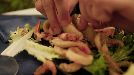 man eating a mixture of fried fish with his hands at the restaurant