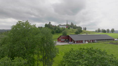 distant view of church on a hill near farm house and fields in foreground