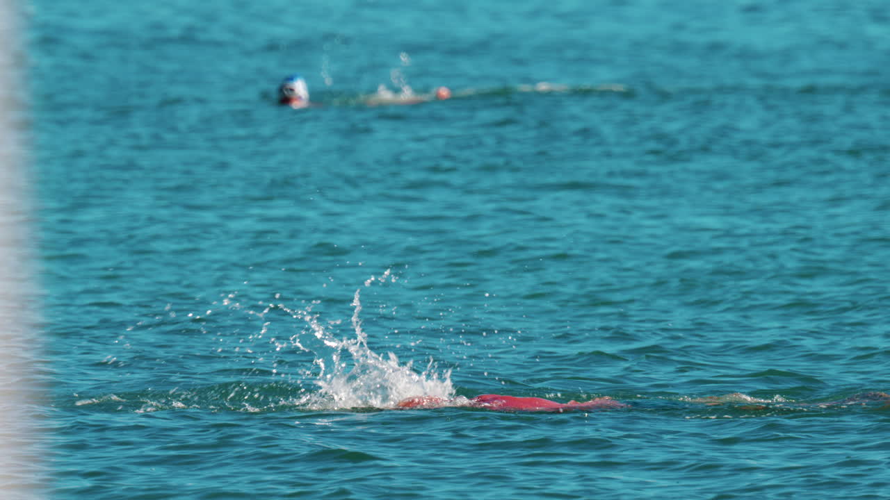 Man swimming freestyle in the calm turquoise water off the coast of Cannes, France