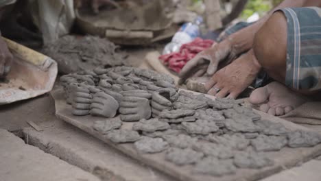 unrecognized hands of poor sculptor making clay pots and idols, slow motion