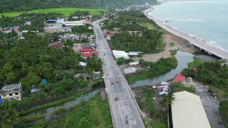 virac downtown in catanduanes, philippines showcasing coastal road, river, and lush greenery, aerial view